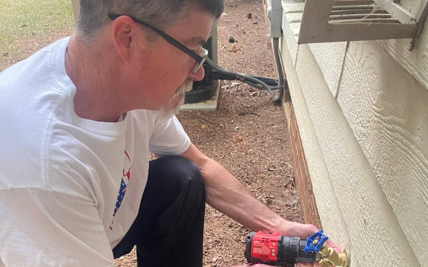 David Baney installing a new outdoor faucet
